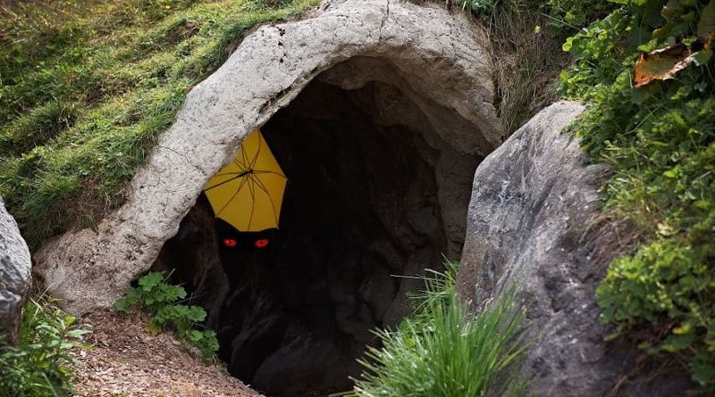 Cave with umbrella hiding in it with red evil eyes